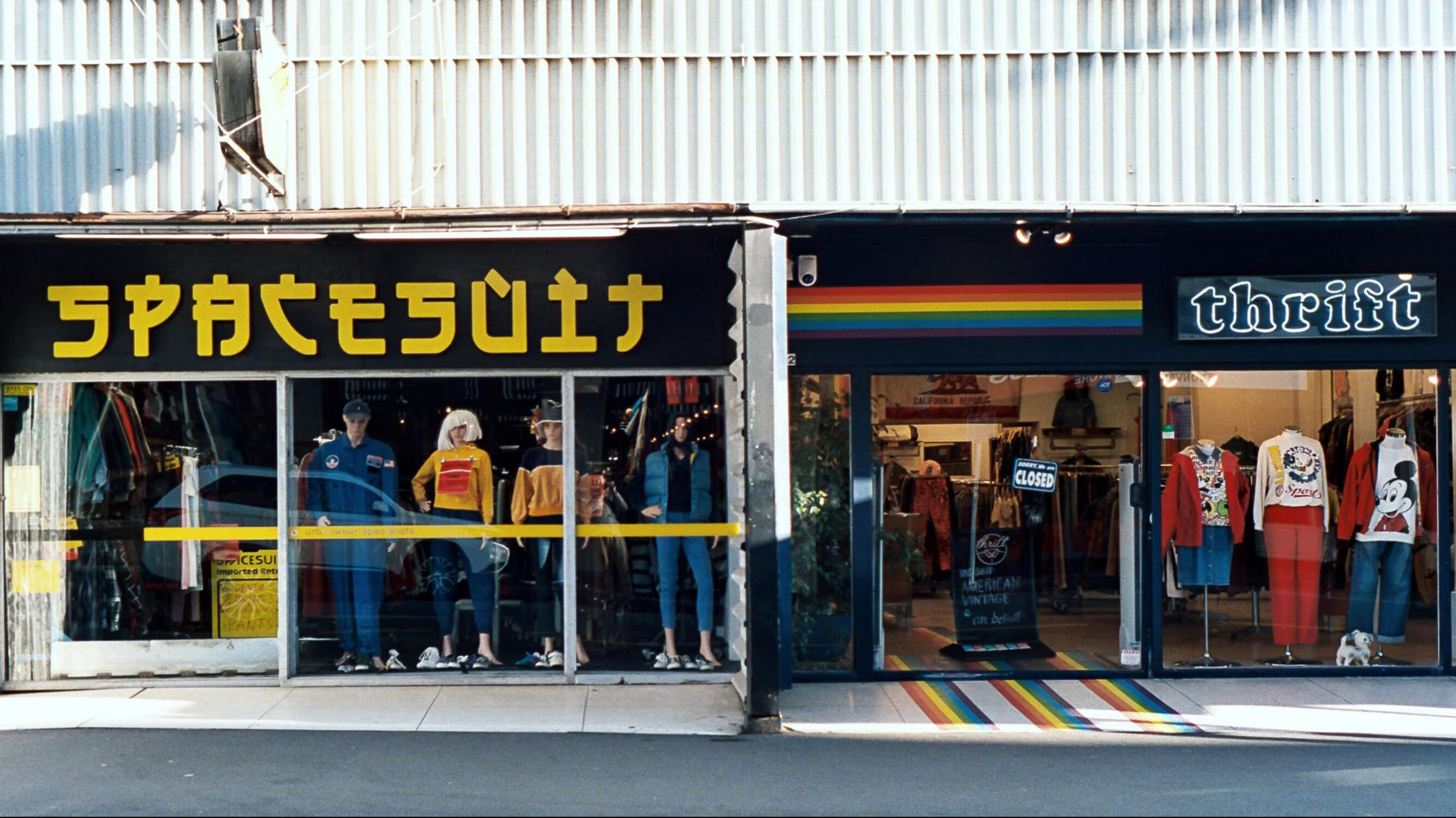 The shopfronts of two op shops, one called Spacesuit, the other Thrift