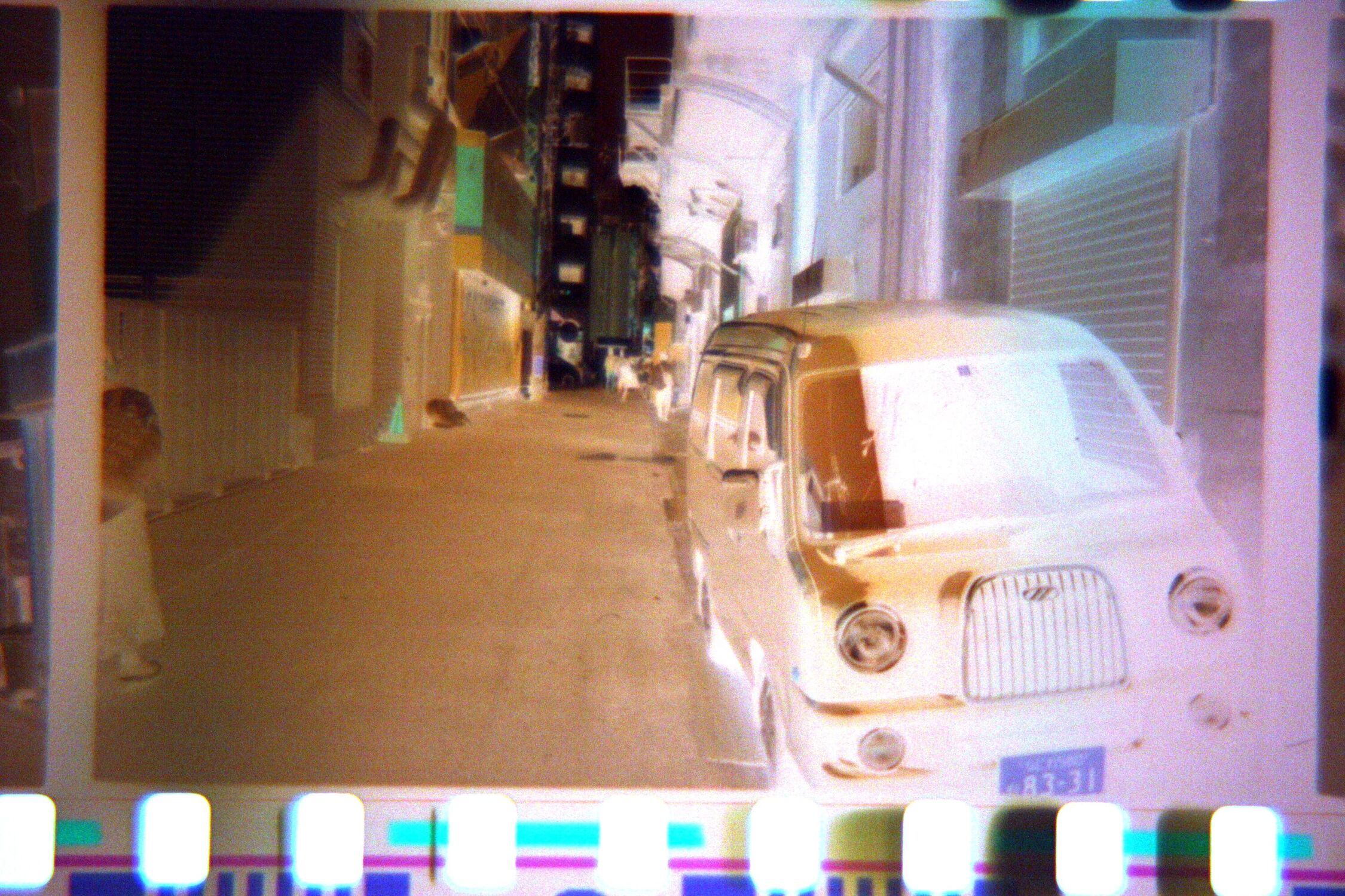 Photographic Negative of a car in an alleyway, now with less brown because the colour has been corrected