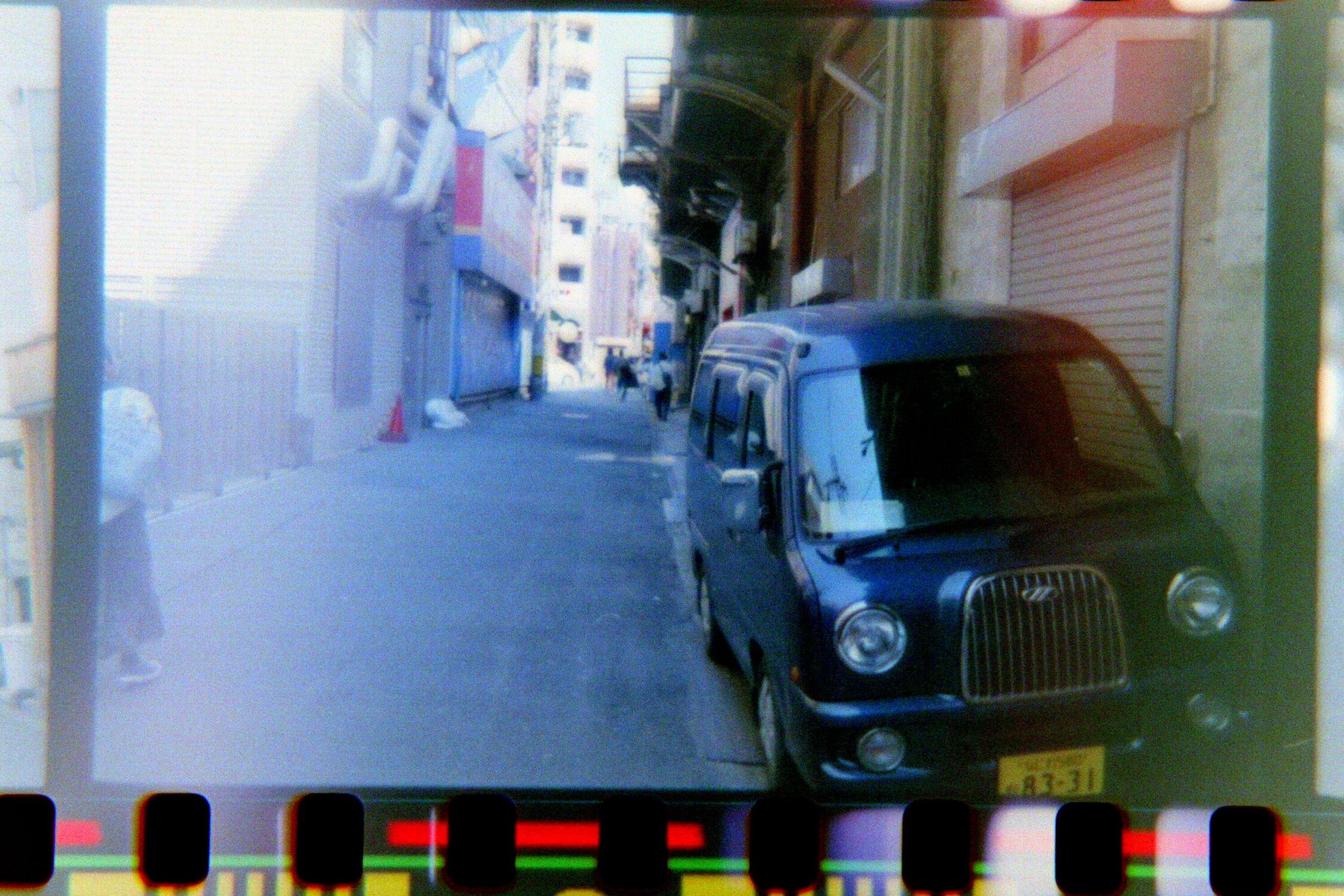 Photographic Negative of a car in an alleyway, now it looks like a regular photo