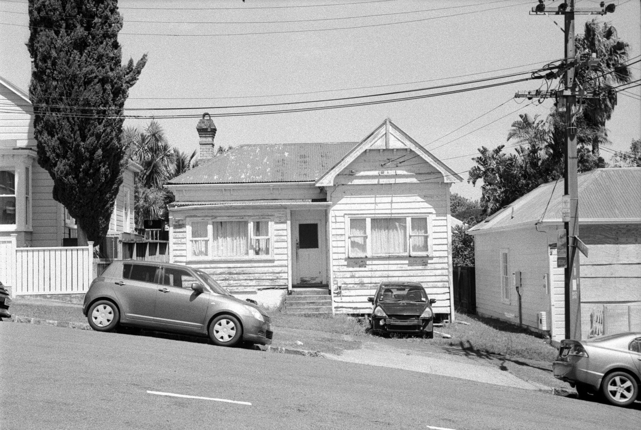 Sloped street, front on view of a run down house